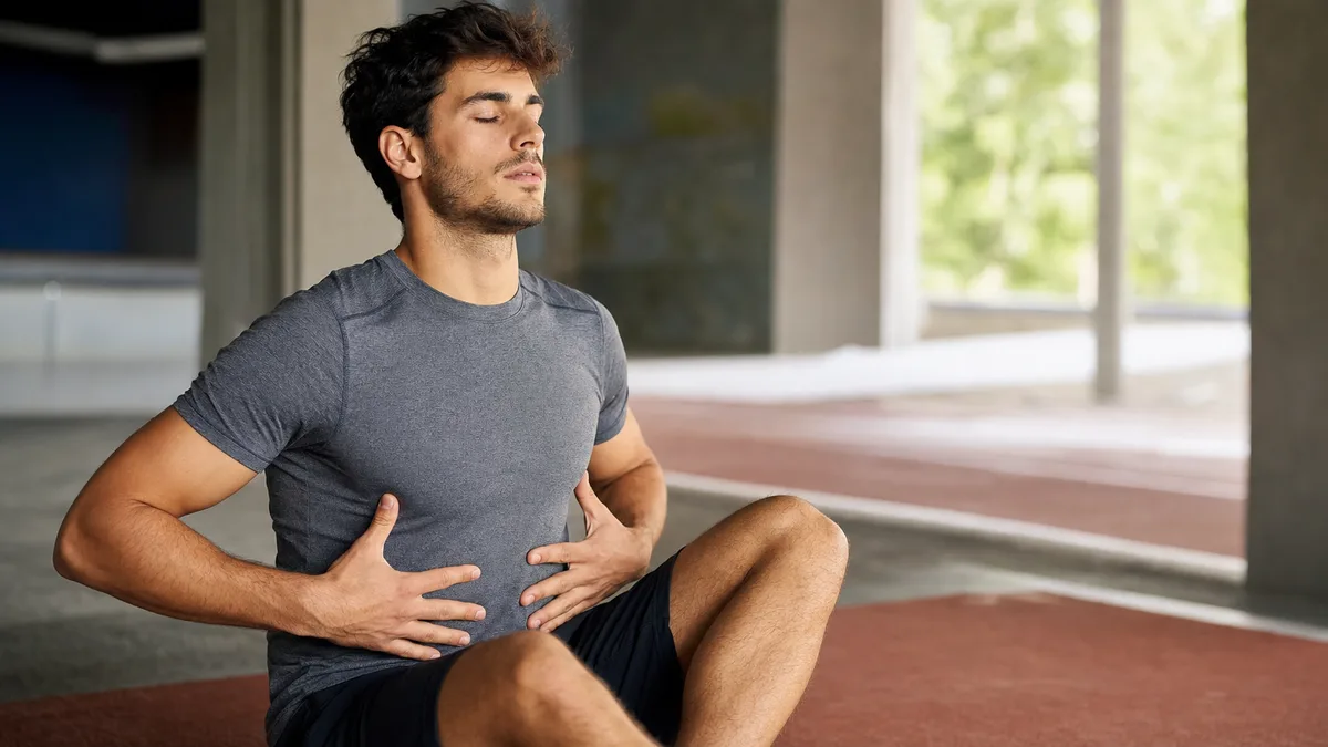 Deportista practicando respiración controlada después del entrenamiento